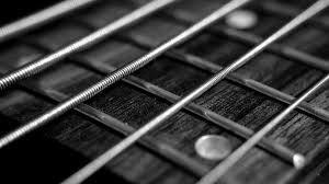 uncoated strings on a fretboard