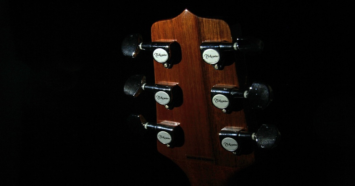 A close-up image of a guitar head with tuners.